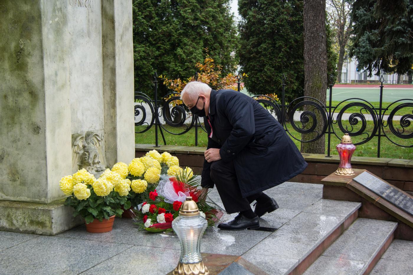 Zdjęcie przedstawia Waldemara Sikorę Burmistrza Miasta i Gminy Busko-Zdrój składającego biało-czerwoną wiązankę kwiatów pod pomnikiem Tadeusza Kościuszki.