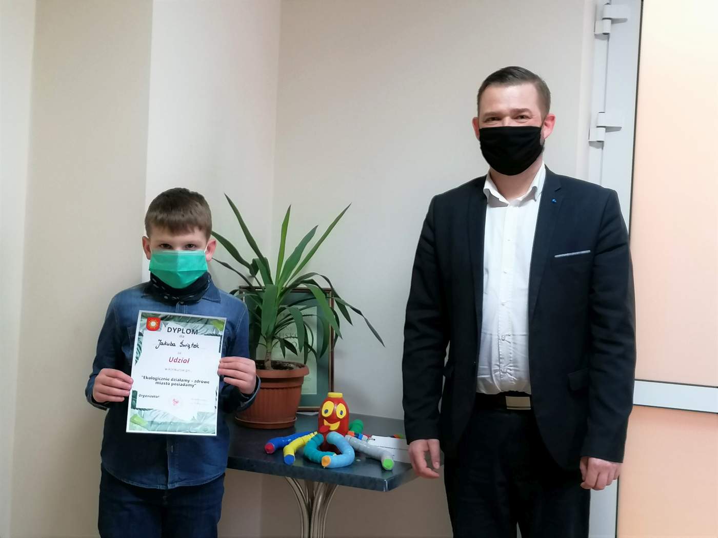 Zdjęcie przedstawia Laureata Konkursu trzymającego dyplom wręczony przez Z-cę Burmistrza Miasta i Gminy Michała Marońskiego