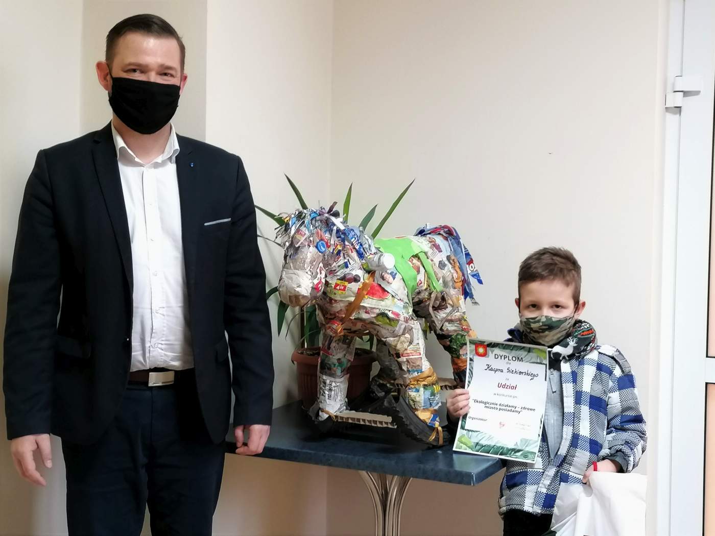 Zdjęcie przedstawia Laureata Konkursu trzymającego dyplom wręczony przez Z-cę Burmistrza Miasta i Gminy Michała Marońskiego